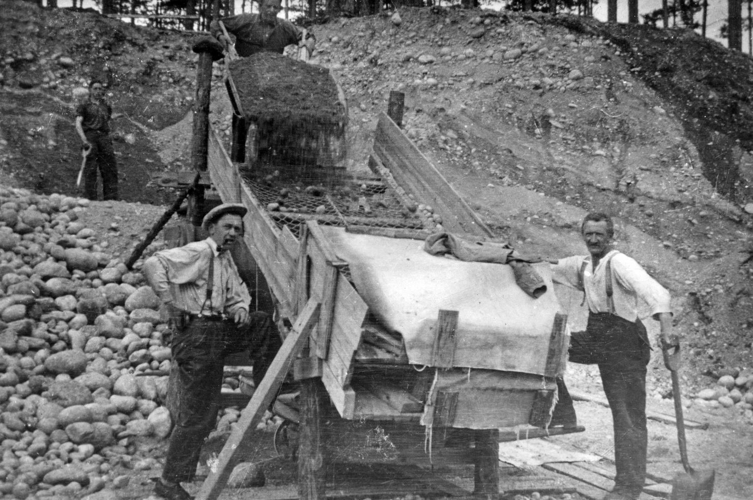 Sort-hvitt bilde av arbeidere som jobber i grustaket