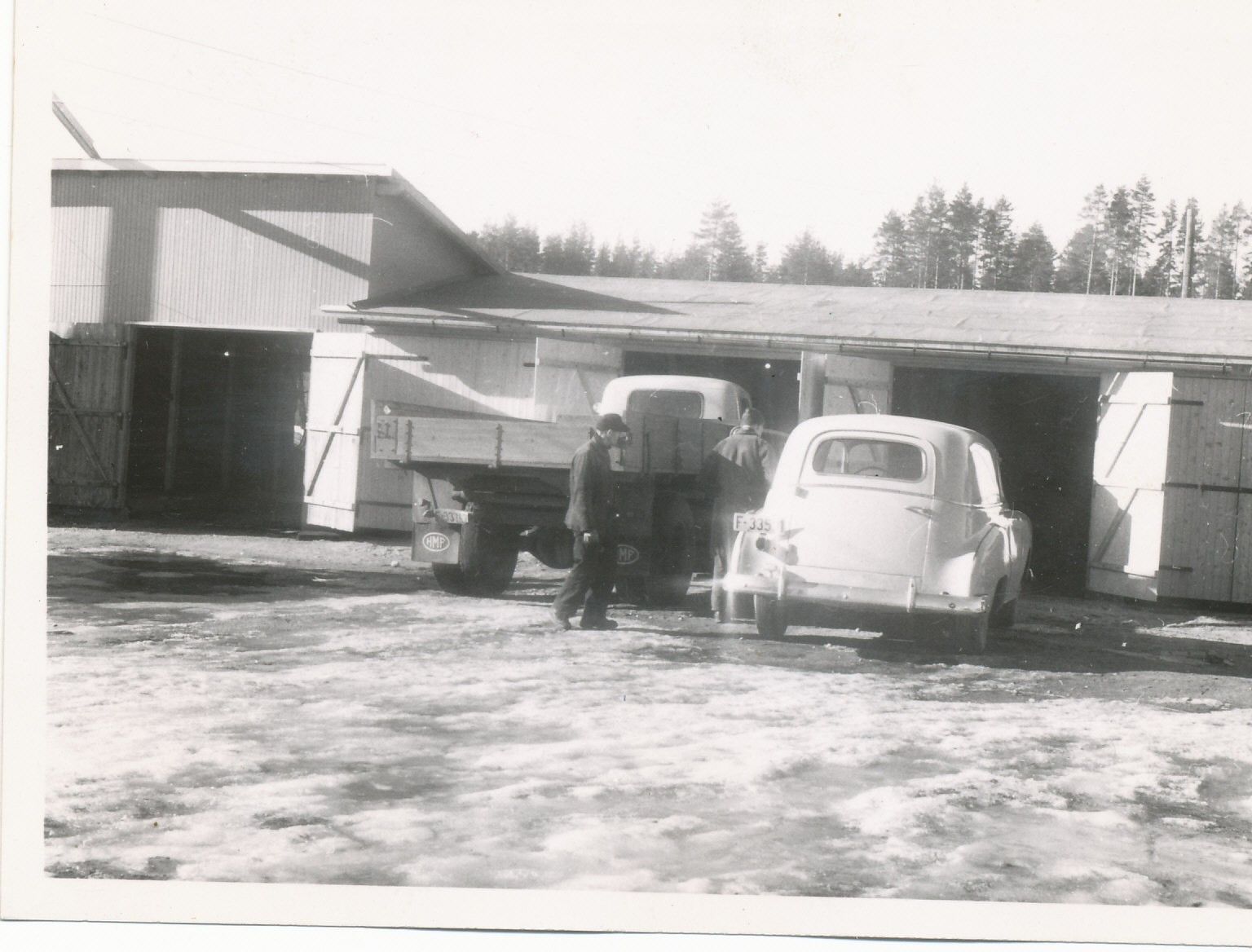 Sort-hvitt bilde av gammel bil og lastebil